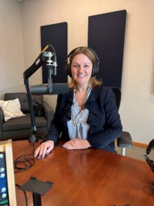 Helen Johnson sitting in front of podcast microphone