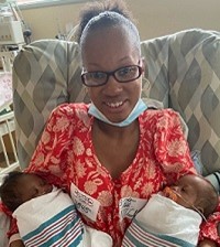 African American women patient at bronson, smiling with newborn twins. 